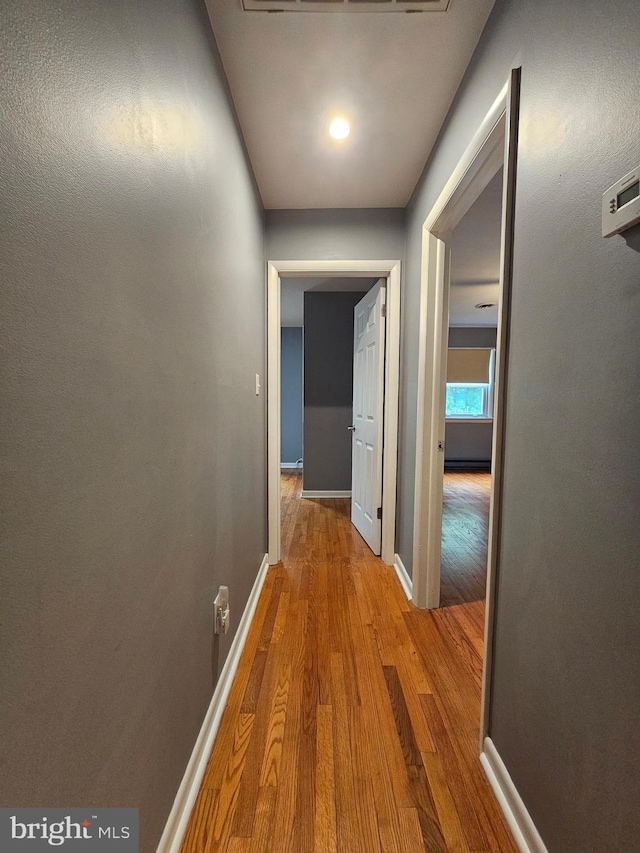 hall with wood finished floors and baseboards