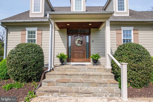 property entrance featuring a shingled roof