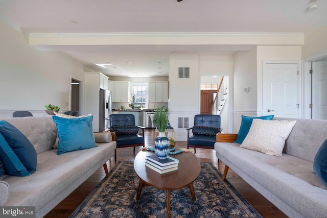 living room featuring dark wood-style floors, stairs, and visible vents