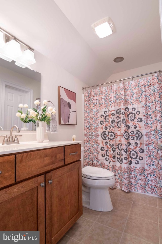 bathroom with tile patterned flooring, vaulted ceiling, a shower with shower curtain, toilet, and vanity
