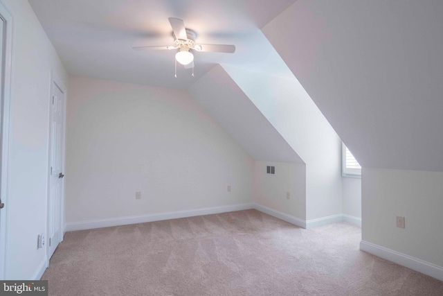 bonus room with ceiling fan, visible vents, baseboards, light colored carpet, and lofted ceiling