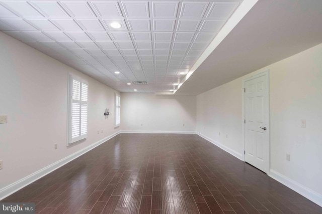 basement featuring dark wood finished floors, visible vents, baseboards, and recessed lighting