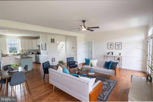 living room featuring visible vents, wood finished floors, ceiling fan, and stairs