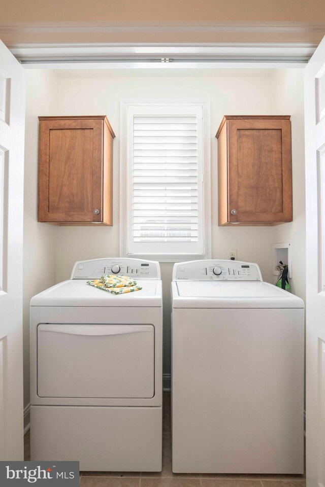 washroom with cabinet space and washing machine and dryer