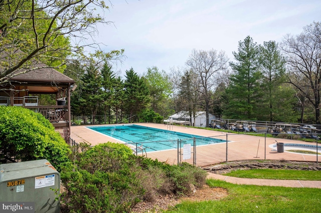 community pool with fence and a gazebo