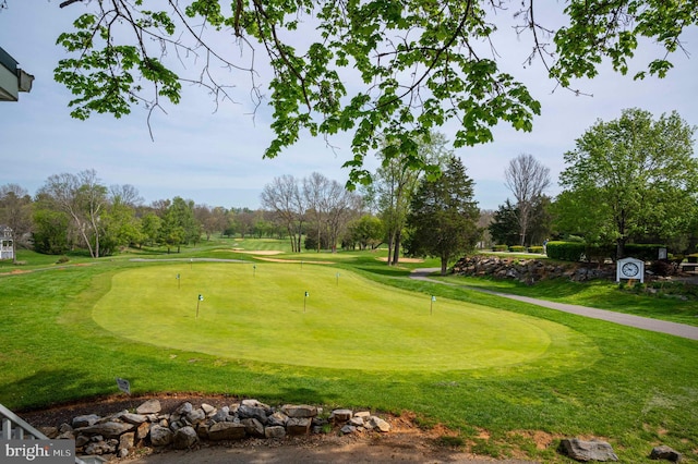 surrounding community with a yard and view of golf course
