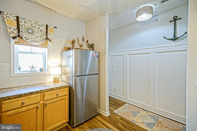 33192 N Village Loop Unit 5204, Lewes, DE 19958 - kitchen featuring brown cabinets, decorative backsplash, dark wood-style floors, and freestanding refrigerator