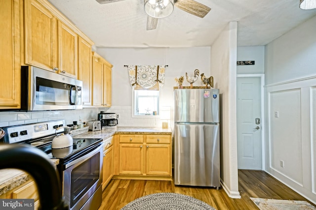 33192 N Village Loop Unit 5204, Lewes, DE 19958 - kitchen featuring tasteful backsplash, appliances with stainless steel finishes, light countertops, ceiling fan, and dark wood-type flooring