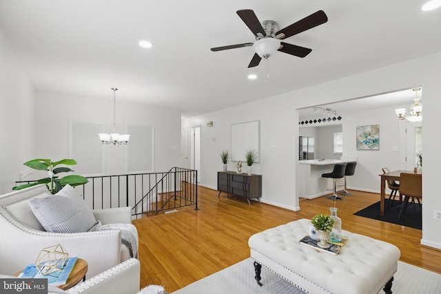 living area with a chandelier, wood finished floors, recessed lighting, a ceiling fan, and baseboards