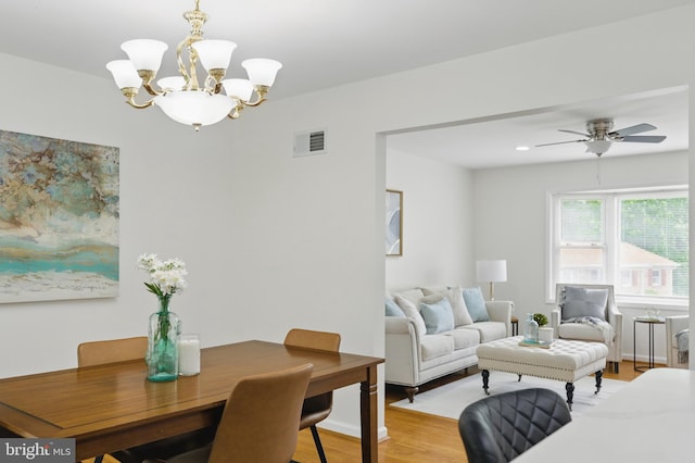 dining space with light wood-type flooring, a chandelier, and ceiling fan