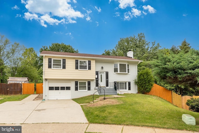 bi-level home with an attached garage, driveway, and a chimney
