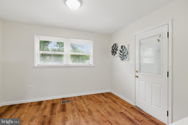 spare room featuring light wood-type flooring and baseboards