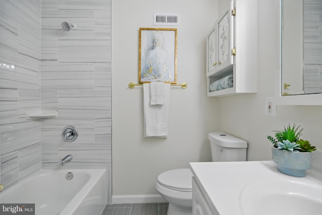 bathroom featuring toilet, vanity, baseboards, and tub / shower combination