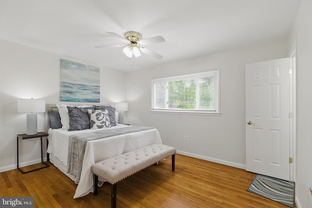bedroom featuring baseboards, wood finished floors, and ceiling fan