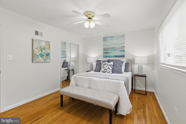 bedroom featuring a closet, light wood-type flooring, baseboards, and ceiling fan