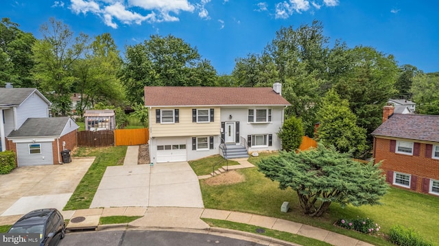 split foyer home with concrete driveway, an attached garage, and a chimney