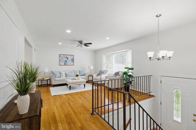 living room with a chandelier, light wood-style floors, recessed lighting, and ceiling fan