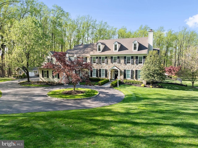 4064 Howell Rd, Malvern, PA 19355 - view of front of home featuring curved driveway, a front lawn, stone siding, and a chimney