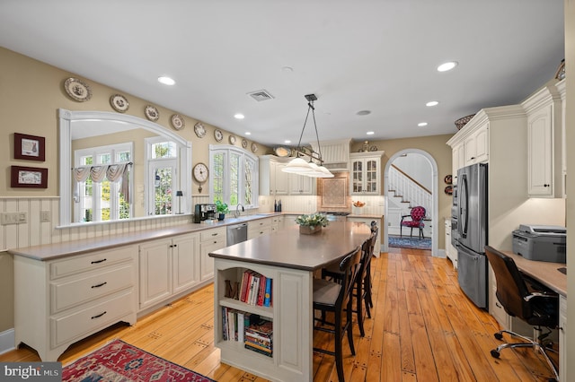 4064 Howell Rd, Malvern, PA 19355 - kitchen featuring white cabinets, appliances with stainless steel finishes, a breakfast bar area, a kitchen island, and visible vents