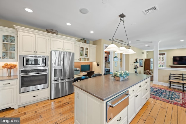 4064 Howell Rd, Malvern, PA 19355 - kitchen featuring visible vents, decorative columns, glass insert cabinets, a warming drawer, and stainless steel appliances