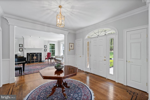 4064 Howell Rd, Malvern, PA 19355 - entryway with ornamental molding, wood finished floors, a lit fireplace, a wainscoted wall, and a notable chandelier