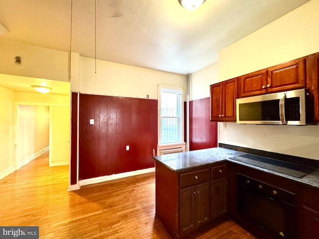 kitchen with black electric stovetop, light wood-style flooring, a peninsula, stainless steel microwave, and wall oven