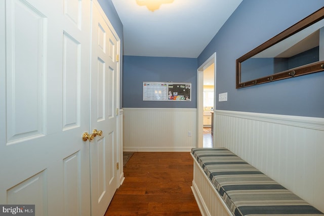 hallway with a wainscoted wall and dark wood-style floors