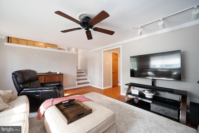 living room with stairway, ornamental molding, ceiling fan, and wood finished floors