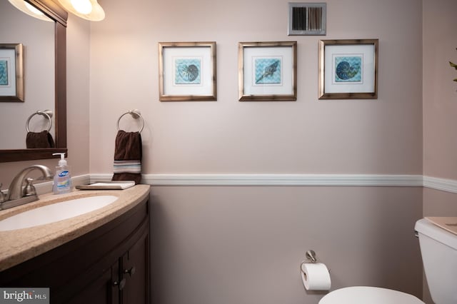 bathroom featuring visible vents, toilet, and vanity