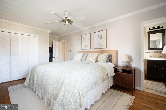 bedroom with ornamental molding, light wood-style floors, a closet, and a sink