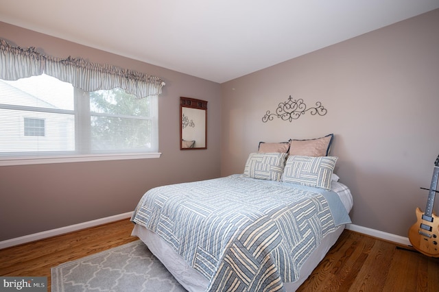 bedroom with wood finished floors and baseboards