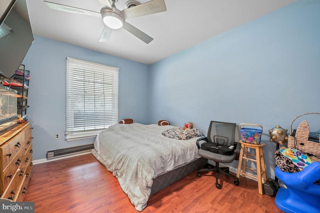 bedroom with a ceiling fan, baseboards, wood finished floors, and a baseboard radiator