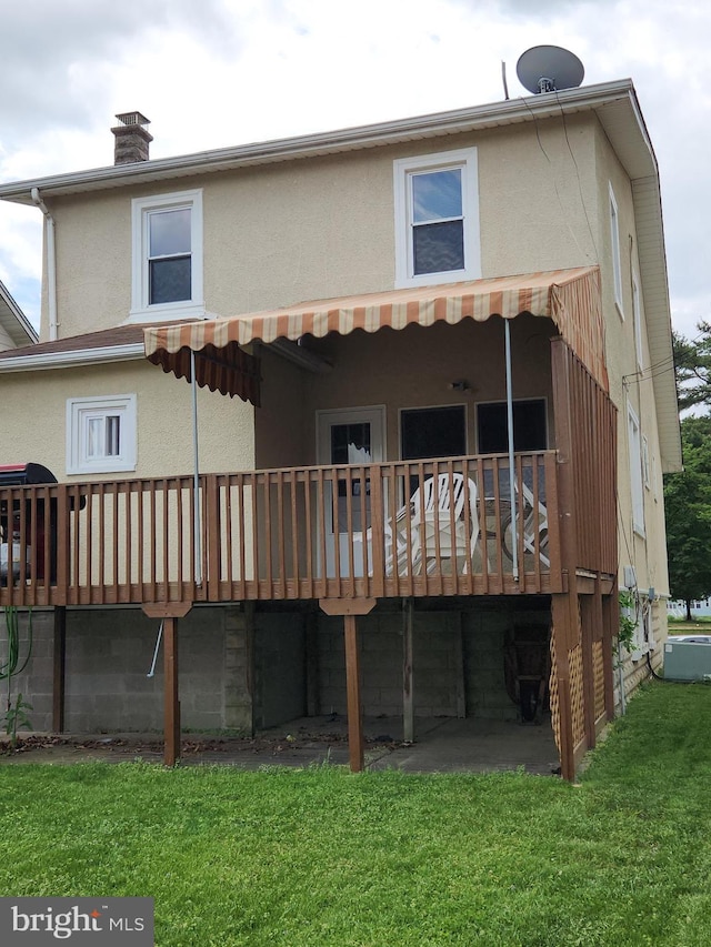 2906 Sylvan Ave, Baltimore, MD 21214 - back of property with a wooden deck, stucco siding, a yard, and a chimney