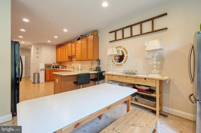 8733 Boulder Ridge Rd, Laurel, MD 20723 - kitchen featuring baseboards, recessed lighting, a peninsula, freestanding refrigerator, and a sink