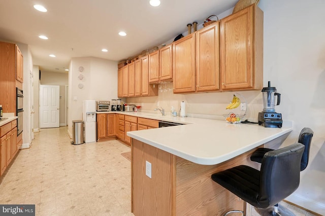 8733 Boulder Ridge Rd, Laurel, MD 20723 - kitchen with a peninsula, recessed lighting, a breakfast bar area, light countertops, and a sink