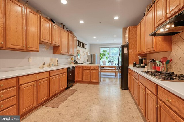 8733 Boulder Ridge Rd, Laurel, MD 20723 - kitchen with under cabinet range hood, black appliances, a peninsula, recessed lighting, and light countertops