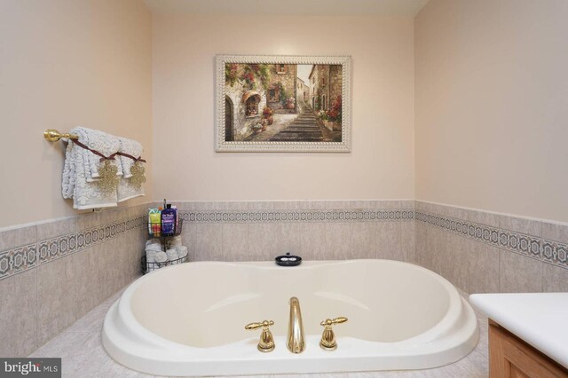 8733 Boulder Ridge Rd, Laurel, MD 20723 - bathroom featuring a garden tub, a wainscoted wall, tile walls, and vanity