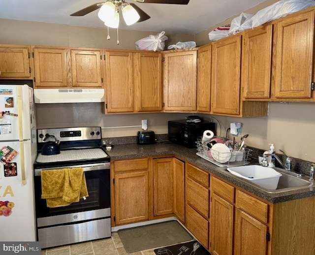 kitchen featuring freestanding refrigerator, under cabinet range hood, stainless steel range with electric cooktop, a sink, and a ceiling fan