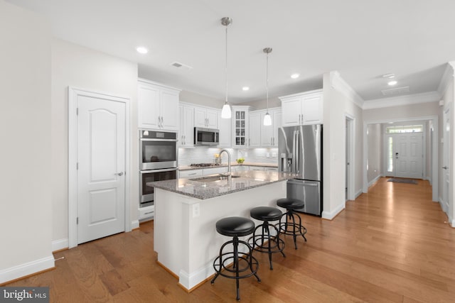 kitchen with ornamental molding, decorative backsplash, white cabinets, and stainless steel appliances
