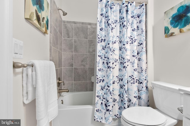 bathroom featuring toilet and shower / bath combination with curtain