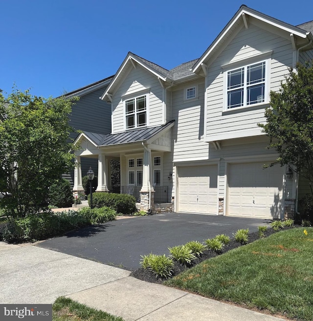 craftsman house with a garage, asphalt driveway, a standing seam roof, a porch, and metal roof