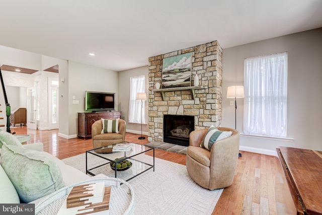 living area featuring wood finished floors, a fireplace, and baseboards