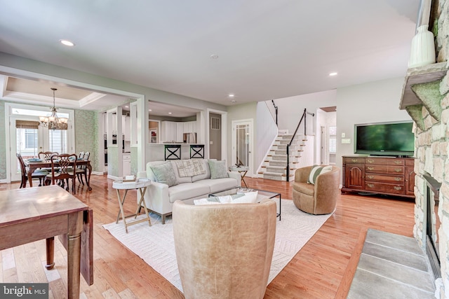 living area with stairway, a chandelier, wood finished floors, recessed lighting, and baseboards