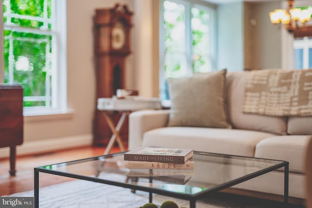 living area featuring healthy amount of natural light, a chandelier, and baseboards