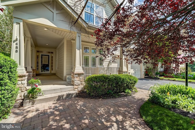 doorway to property featuring covered porch and driveway