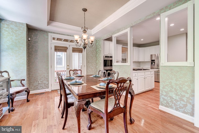 dining space with wallpapered walls, light wood-style flooring, a chandelier, baseboards, and ornamental molding