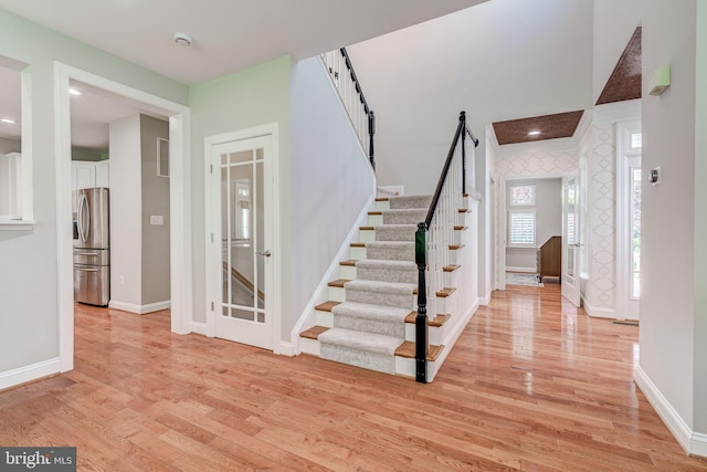 foyer featuring stairway, light wood-type flooring, and baseboards