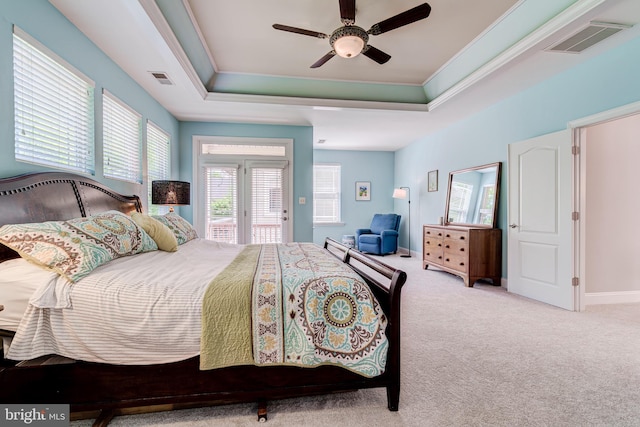 carpeted bedroom featuring multiple windows, ornamental molding, a raised ceiling, access to exterior, and a ceiling fan
