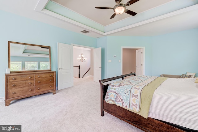 bedroom featuring a raised ceiling, a chandelier, light carpet, and a ceiling fan