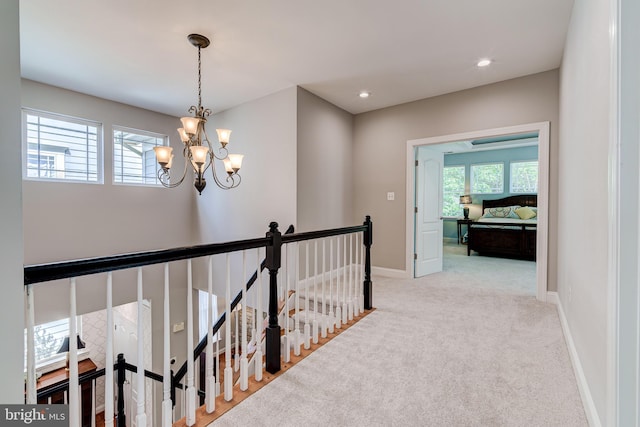 corridor with an upstairs landing, healthy amount of natural light, a chandelier, carpet floors, and recessed lighting